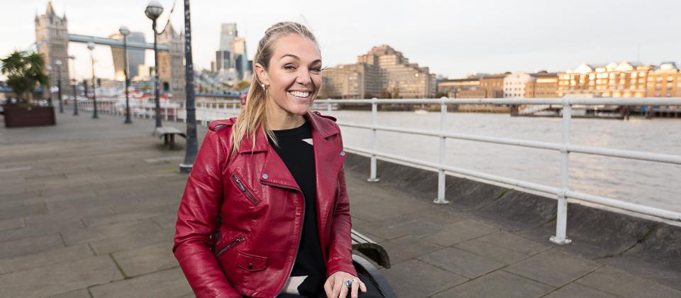 Sophie Morgan smiles on London's South Bank with the Thames and London Bridge in the background.