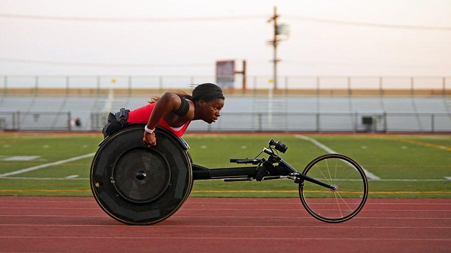A woman in a racing wheelchair on a track
