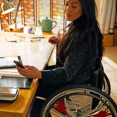 A wheelchair user looks at her phone