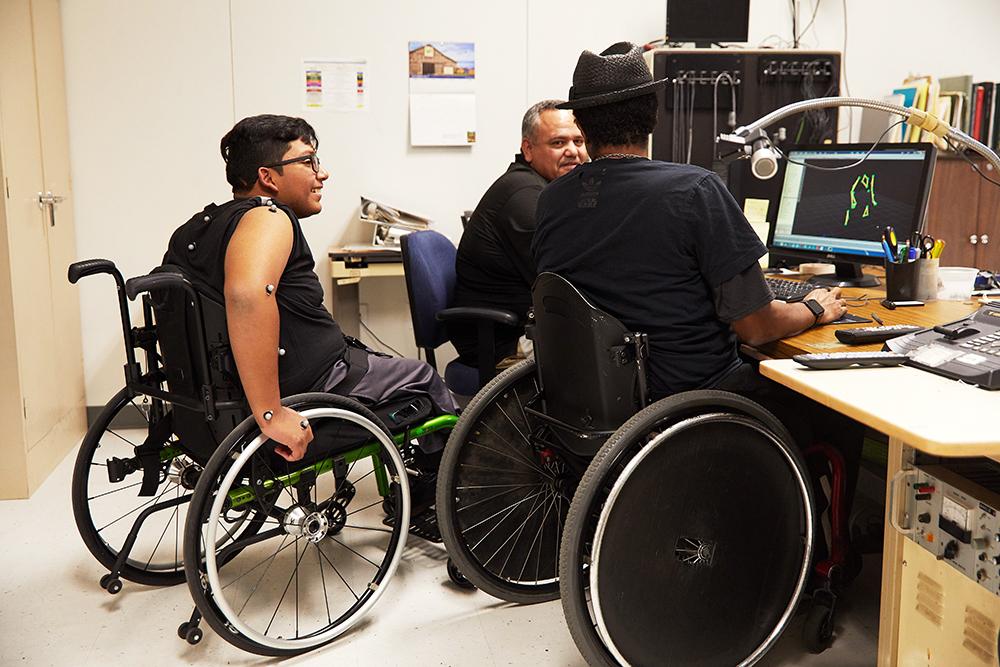 Innovators view a computer image of an exoskeleton